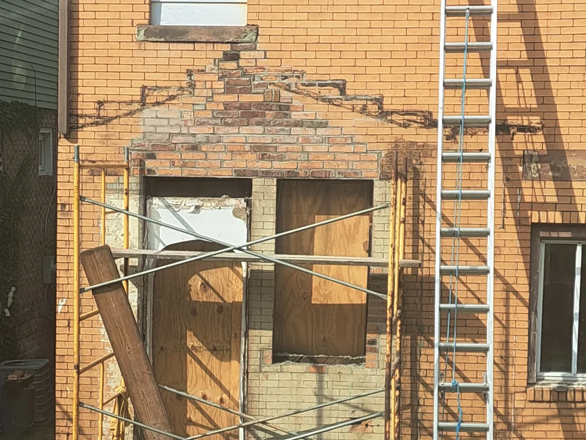 Rear brick wall opened up and shored with scaffolding and a ladder in place