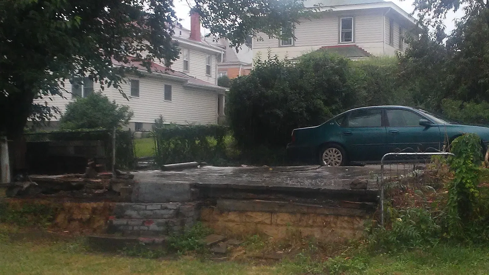 Cleared lot after a structure was removed, with the old stone foundation cut down to grade
