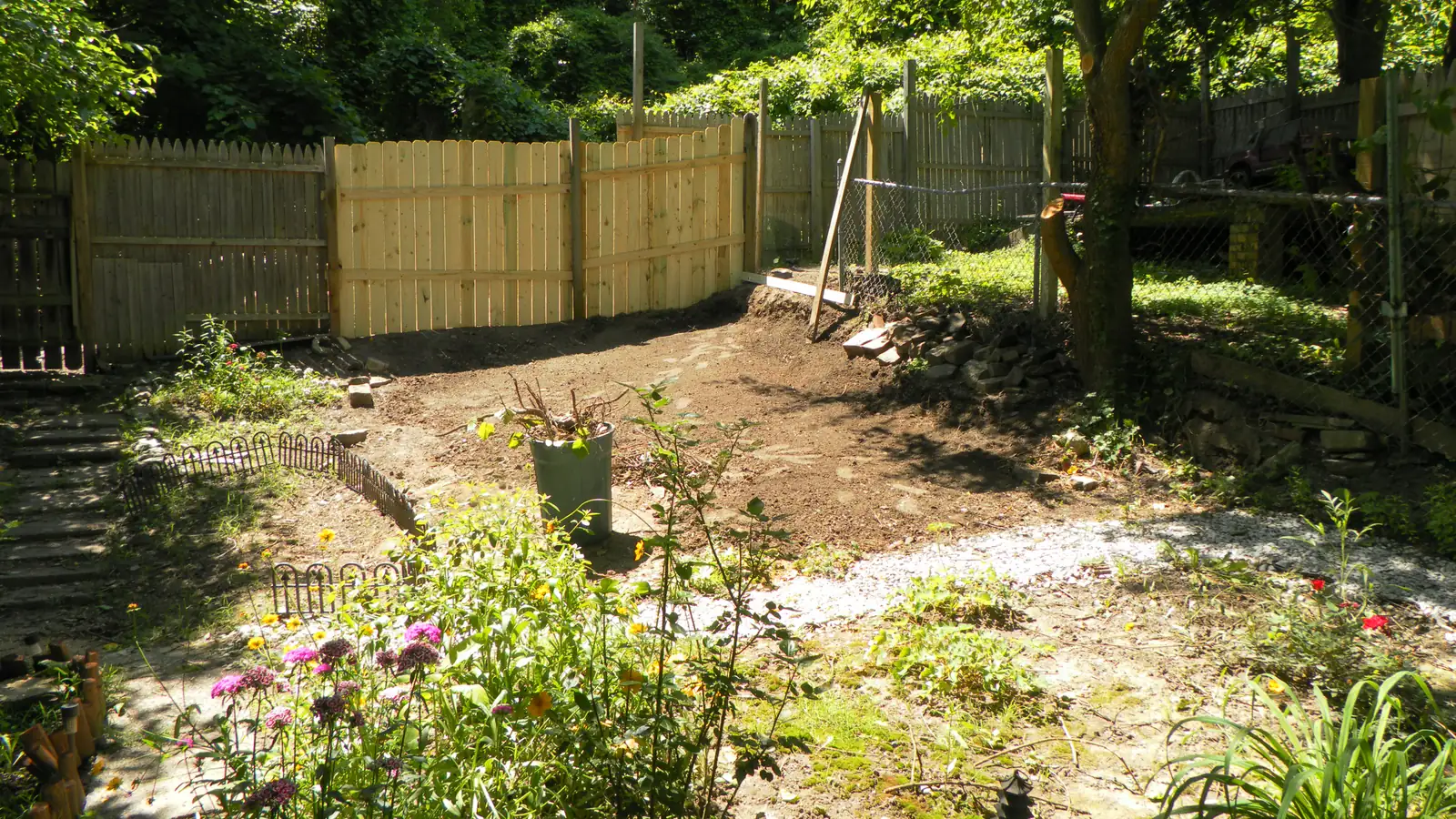 Back yard cleared and levelled after a structure was taken down, with a new fence along the line