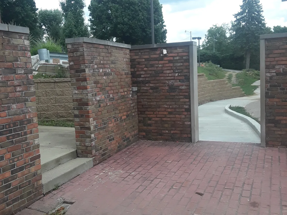 Brick piers and brick paving laid at the side of a building